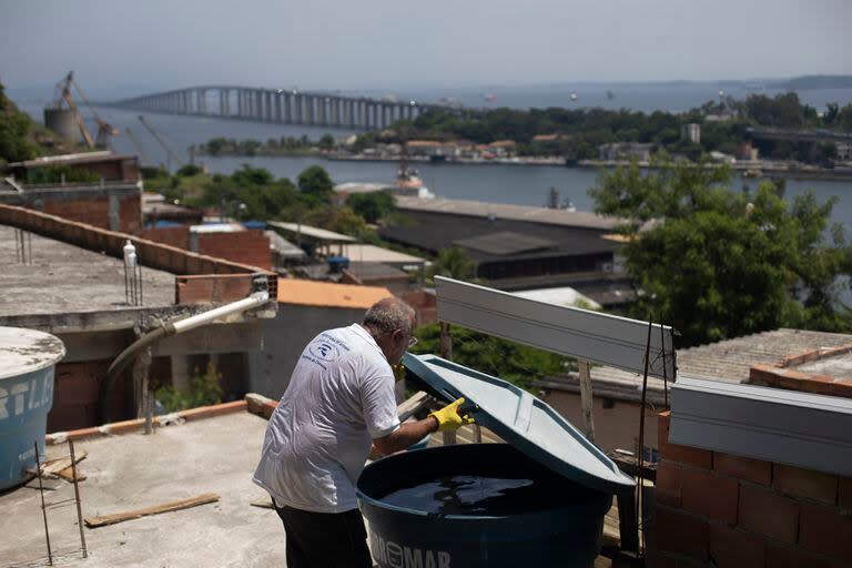 Augusto César, trabajador municipal que combate enfermedades endémicas, revisa un tinaco donde los mosquitos pueden dejar huevos, en la favela de Morro da Penha, en Niterói, Brasil