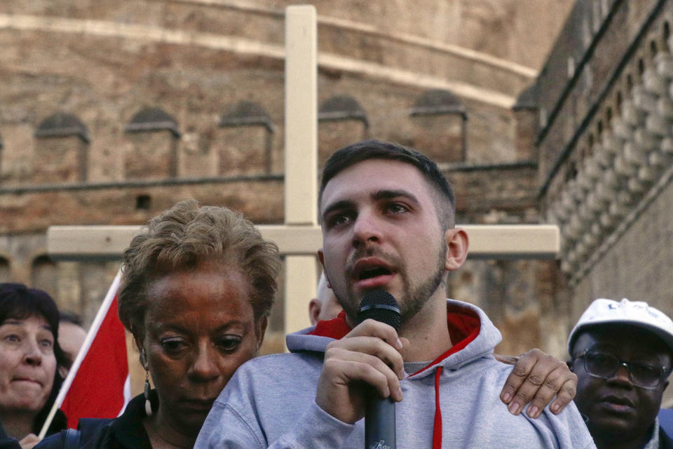 Sex abuse survivor Alessandro Battaglia, right, is hugged by survivor and founding member of the ECA (Ending Clergy Abuse), Denise Buchanan, as he speaks during a twilight vigil prayer near Castle Sant' Angelo, in Rome, Thursday, Feb. 21, 2019. Pope Francis opened a landmark sex abuse prevention summit Thursday by warning senior Catholic figures that the faithful are demanding concrete action against predator priests and not just words of condemnation. (AP Photo/Gregorio Borgia)
