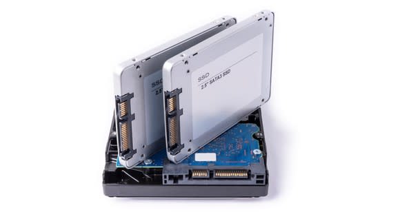 Two SSDs placed on top of an HDD.