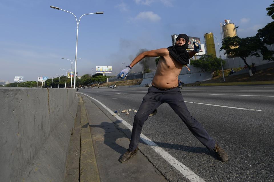 A supporter of Venezuelan opposition leader Juan Guaido clashes with security forces in Caracas on April 30, 2019. - Venezuelan opposition leader and self-proclaimed acting president  Juan Guaido said on Tuesday that troops had joined his campaign to oust President Nicolas Maduro as the government vowed to put down what it said was an attempted coup. (Photo by Matias Delacroix / AFP) / The erroneous mention[s] appearing in the metadata of this photo by Matias Delacroix has been modified in AFP systems in the following manner: [A supporter of Venezuelan opposition leader Juan Guaido] instead of [A Venezuelan]. Please immediately remove the erroneous mention[s] from all your online services and delete it (them) from your servers. If you have been authorized by AFP to distribute it (them) to third parties, please ensure that the same actions are carried out by them. Failure to promptly comply with these instructions will entail liability on your part for any continued or post notification usage. Therefore we thank you very much for all your attention and prompt action. We are sorry for the inconvenience this notification may cause and remain at your disposal for any further information you may require. (Photo: Matias Delacroix /AFP/Getty Images)