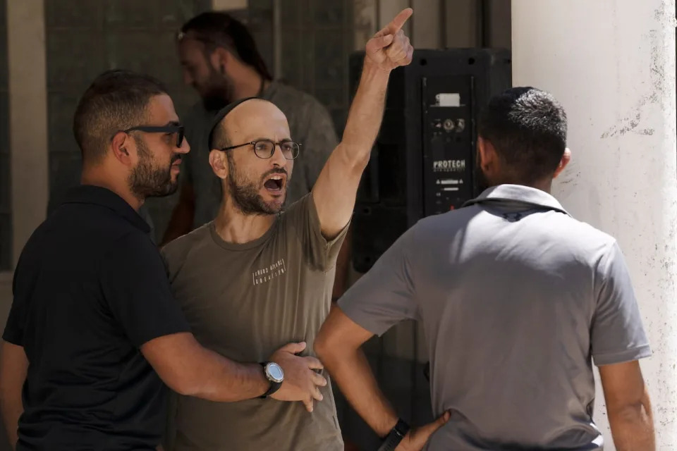 An Israeli settler heckles Israelis protesting near the home of far-right National Security Minister Itamar Ben Gvir against plans by Benjamin Netanyahu's government efforts to overhaul the judiciary, in the West Bank settlement of Kiryat Arba on Friday, Aug. 25, 2023.