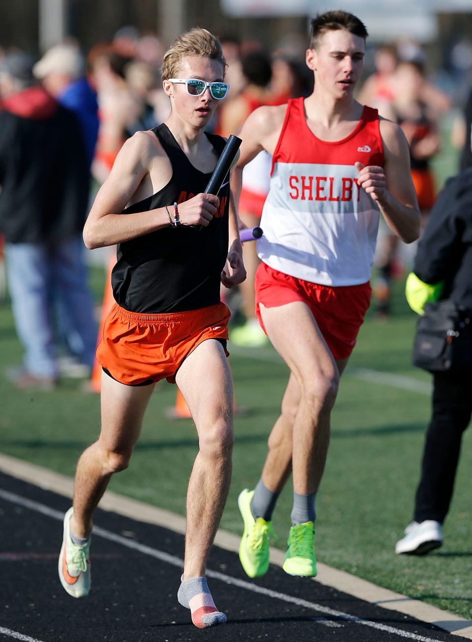 Ashland High School's Luke Wash and Shelby High School's Huck Finnegan compete in the 4x800 relay at the Madison Track Invitational at Madison Comprehensive High School Thursday, March 30, 2023. TOM E. PUSKAR/ASHLAND TIMES-GAZETTE