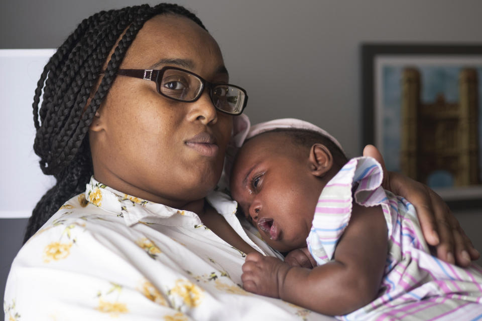 Asian Davis, 33, of Sikeston, Mo., cradles her 8-month-old daughter Mira White during an interview on Oct. 3, 2023, in St. Louis. Davis and her lawyers say Mira suffered brain damage in March after developing bacterial meningitis tied to powdered infant formula contaminated with Cronobacter sakazakii, a germ known to cause severe disease in young babies. (AP Photo/Michael Thomas)