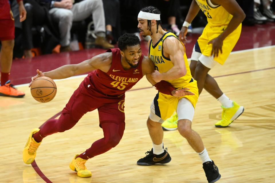 Apr 12, 2024; Cleveland, Ohio, USA; Cleveland Cavaliers guard Donovan Mitchell (45) dribbles beside Indiana Pacers guard Andrew Nembhard (2) in the fourth quarter at Rocket Mortgage FieldHouse. Mandatory Credit: David Richard-USA TODAY Sports