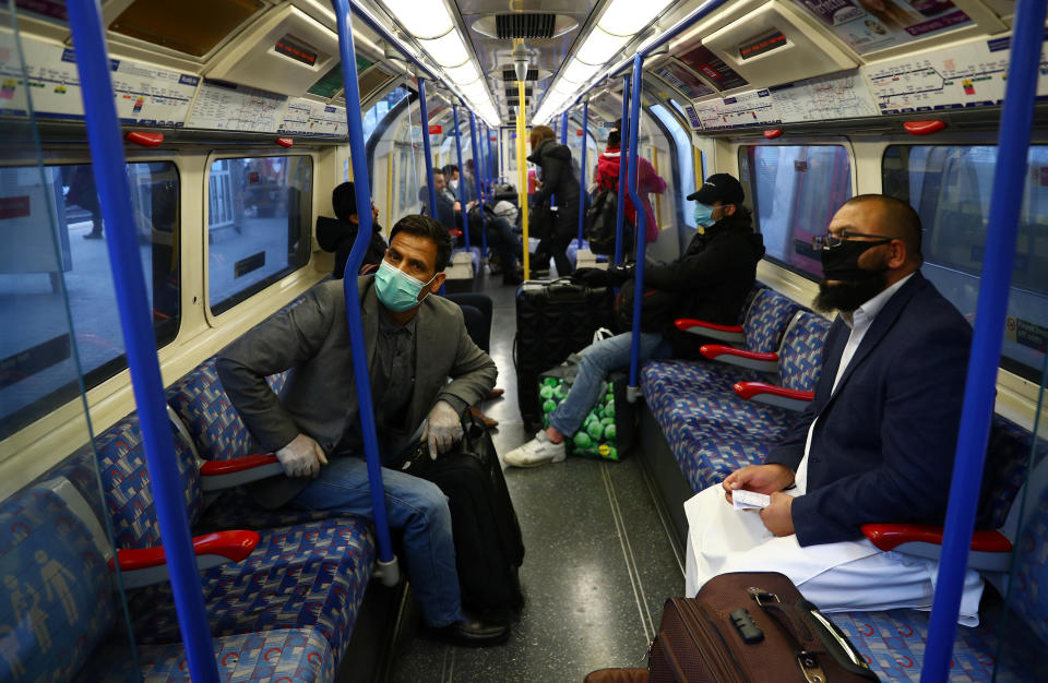 Commuter's wearing protective face mask's as people travel on a Piccadilly line train while the spread of the coronavirus disease (COVID-19) continues, London, Britain, March 24, 2020. REUTERS/Hannah McKay