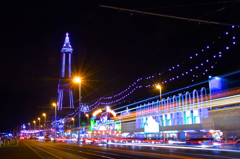 The Famous Blackpool Tower and lights along the stretch of promenade known as the Golden Mile in Blackpool, Lancashire at night, photographed on a long exposure with light streaks during the yearly 'illuminations' spectacle.