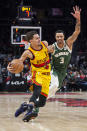 Atlanta Hawks guard Trae Young (11) drives past Milwaukee Bucks guard George Hill (3) during the second half of an NBA basketball game Monday, Jan. 17, 2022, in Atlanta. (AP Photo/Hakim Wright Sr.)