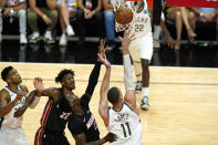 Milwaukee Bucks center Brook Lopez (11) shoots as Miami Heat forward Jimmy Butler (22) and center Bam Adebayo (13) defend during the second half of Game 4 of an NBA basketball first-round playoff series, Saturday, May 29, 2021, in Miami. (AP Photo/Lynne Sladky)