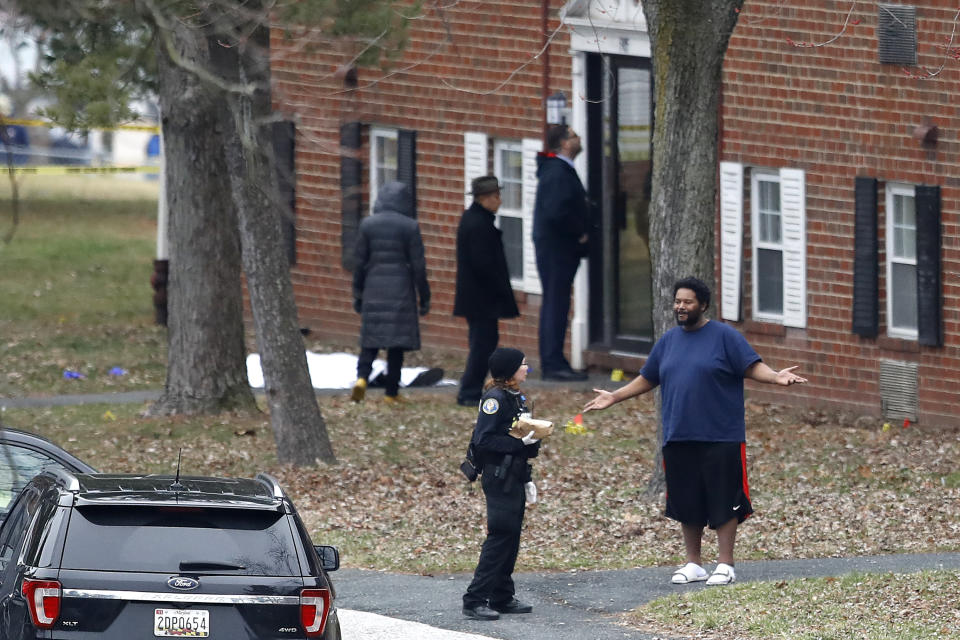 A person reacts while talking to an official at an apartment complex near the scene of a shooting, Wednesday, Feb. 12, 2020, in Baltimore. Two law enforcement officers with a fugitive task force were injured and a suspect died in the shooting, the U.S. Marshals Service said. (AP Photo/Julio Cortez)