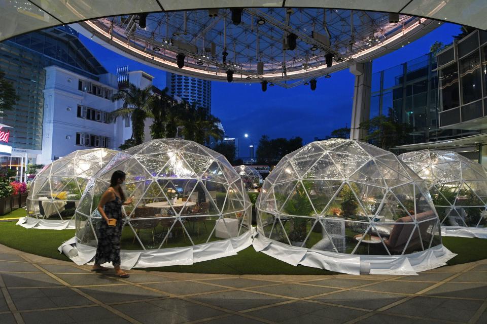 SINGAPORE, Oct. 21, 2020 -- A woman walks past dining domes, installations which help prevent the spread of the COVID-19 epidemic, at Capitol Singapore Outdoor Plaza, Singapore, on Oct. 21, 2020. (Photo by Then Chih Wey/Xinhua via Getty) (Xinhua/Then Chih Wey via Getty Images)