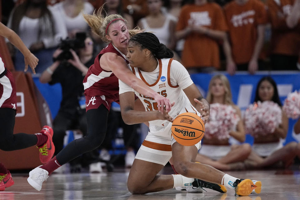 Texas forward Madison Booker, front, and Alabama guard Sarah Ashlee Barker, rear, scramble for a loose ball during the second half of a second-round college basketball game in the women’s NCAA Tournament in Austin, Texas, Sunday, March 24, 2024. (AP Photo/Eric Gay)
