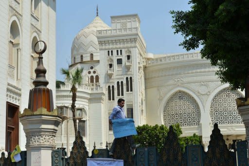 An Egyptian protester stands on the gate of the presidential palace during a demonstration in Cairo onlast week by people wanting to air grievances directly with President Mohamed Morsi. Instead of being sworn in before parliament, Morsi took the presidential oath before the constitutional court