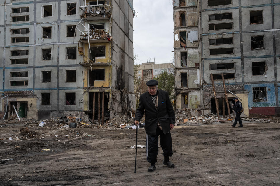 A man walks by an apartment block that was destroyed by a Russian missile attack.