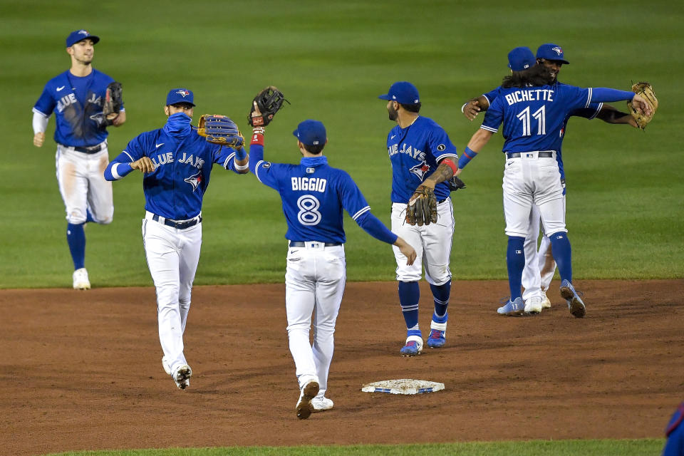 Toronto Blue Jays celebrate a 4-1 win over the New York Yankees in a baseball game in Buffalo, N.Y., Thursday, Sept. 24, 2020. Toronto clinched a postseason berth with the win. (AP Photo/Adrian Kraus)