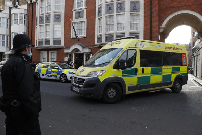 Police officers stand at an entrance to the King Edward VII Hospital where Prince Philip is being treated for an infection, as an ambulance is driven out, in London, Monday, March 1, 2021. (AP Photo/Frank Augstein)