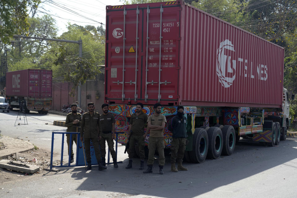 Police officers stand guard at a barricaded road leading to the residence of former Prime Minister Imran Khan, in Lahore, Pakistan, Thursday, March 16, 2023. A Pakistani court on Thursday extended a pause for a day in an operation aimed at arresting the former premier Khan, a sign of easing tension in the country's cultural capital of Lahore where 24-hours-long clashes erupted this week when police tried to arrest Khan for failing to appear before a court in the capital. (AP Photo/K.M. Chaudary)