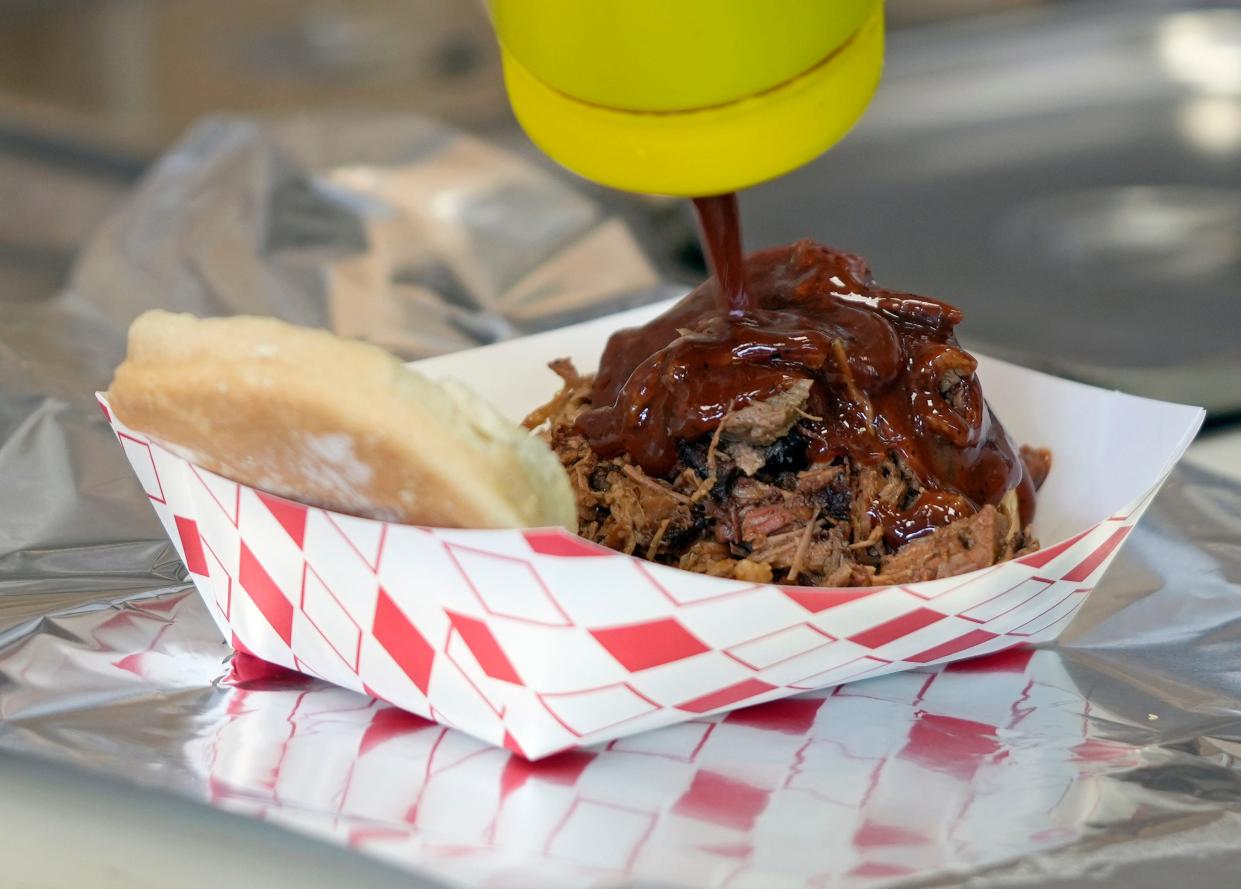 Nov. 28, 2023; Columbus, Oh., USA;
A beef brisket sandwich from BBQ Alley is covered in a house-made sauce before serving.