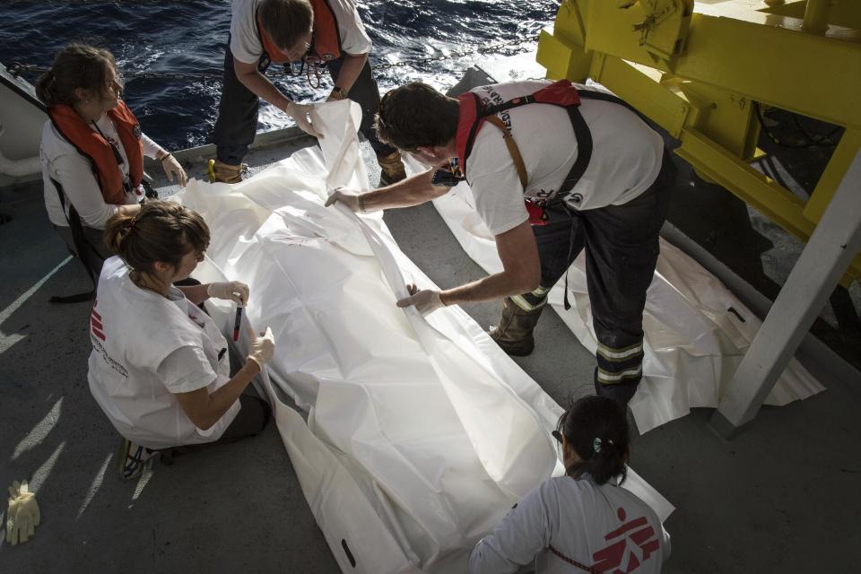 Varios socorristas cubren el cadáver de un migrante a bordo del barco MV Aquarius en aguas del mar Mediterráneo, a unos 25 kilómetros (22 millas) al norte de Sabrata, Libia, el viernes 13 de enero de 2017. Un total de 193 personas y dos cadáveres fueron recuperados en aguas internacionales. El barco a cargo de las organizaciones humanitarias MSF y SOS recogió a 183 hombres y 10 mujeres, todos migrantes procedentes de países africanos como Nigeria, Gambia y Senegal. Los migrantes serían llevados a Italia, según lo previsto. El sábado 14 de enero, sólo 4 personas sobrevivieron al naufragio de una embarcación con más de 100 migrantes, dijeron organizaciones de asistencia. (AP Foto/Sima Diab)