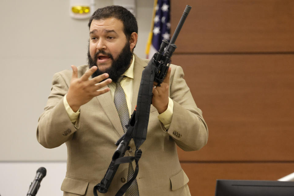 FILE - Broward County Sheriff's Office crime lab manger George Bello holds the weapon used by Marjory Stoneman Douglas High School shooter Nikolas Cruz as he testifies during the penalty phase in Cruz's trial at the Broward County Courthouse in Fort Lauderdale, Fla., Tuesday, Aug. 2, 2022. Cruz previously plead guilty to all 17 counts of premeditated murder and 17 counts of attempted murder in the 2018 shootings. (Amy Beth Bennett/South Florida Sun Sentinel via AP, Pool, File)