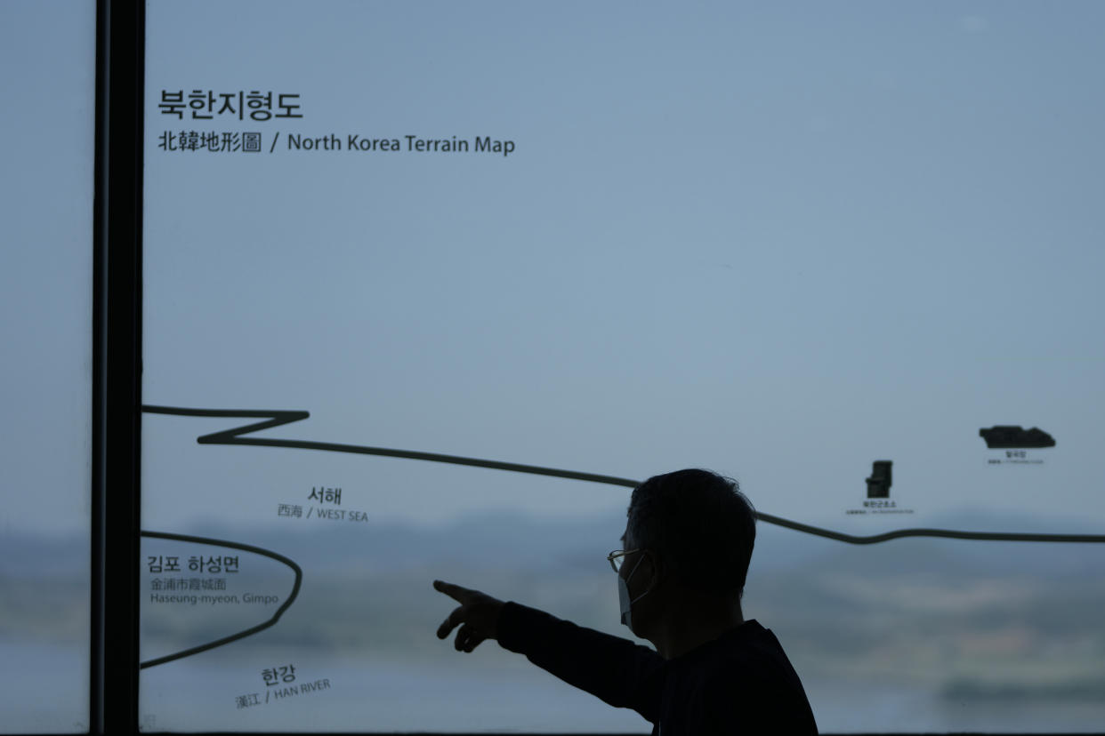 A man talks near a map of North Korea at the unification observatory in Paju, South Korea, Thursday, May 12, 2022. North Korea imposed a nationwide lockdown Thursday to control its first acknowledged COVID-19 outbreak after holding for more than two years to a widely doubted claim of a perfect record keeping out the virus that has spread to nearly every place in the world. (AP Photo/Lee Jin-man)