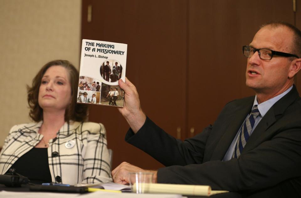 Attorney Craig Vernon holds up a book by Joseph L. Bishop at a news conference on April 5, 2018, in Salt Lake City. (Photo: George Frey/Getty Images)