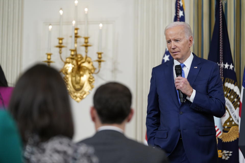 President Biden holding a microphone.