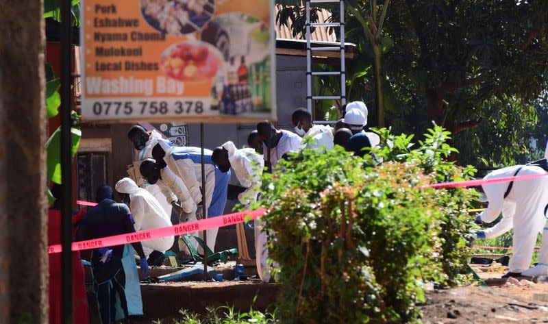 Ugandan explosives experts inspect the debris at the scene of an explosion in Komamboga, on the northern outskirts of Kampala