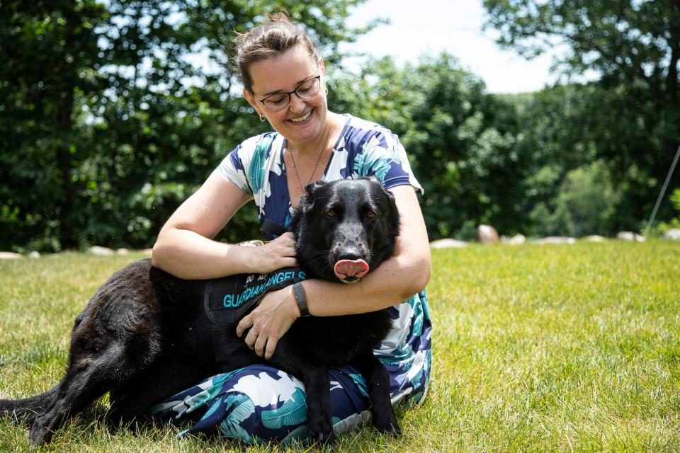 Army veteran Kate Melcher with her Guardian Angel service dog Cat in Ann Arbor on June 30, 2022.