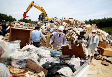 Local residents pile up household waste, caused by a flooding, at a temporary waste-collection point at Mabi Clean Center in Kurashiki, Okayama Prefecture, Japan, July 13, 2018. REUTERS/Issei Kato