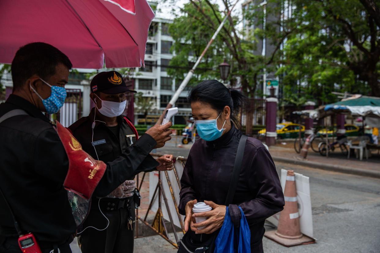 A woman has her temperature taken before entering Lumpini Park after Thailand's lockdown was partially lifted on May 3, 2020, in Bangkok. On May 3, the Thai Government decided to partially lift the lockdown imposed to contain the spread of coronavirus. Markets, parks, barber shops and restaurants are among businesses allowed to open with proper social distancing measures. Thailand currently has 2,969 confirmed cases of COVID-19.