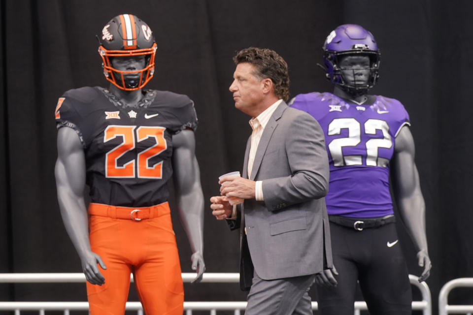 Oklahoma State head coach Mike Gundy walks on stage to speak to reporters at the NCAA college football Big 12 media days in Arlington, Texas, Wednesday, July 13, 2022. (AP Photo/LM Otero)