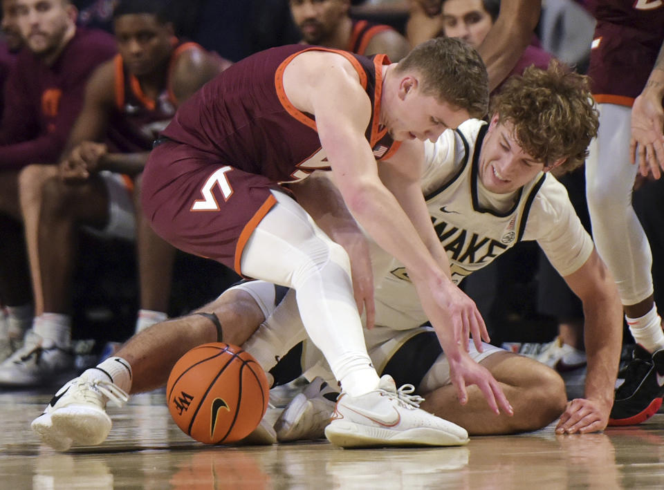 Virginia Tech's Sean Pedulla, left, and Wake Forest's Zach Kellar battle for a loose ball during the second half of an NCAA college basketball game, Saturday, Dec. 30, 2023 in Winston-Salem, N.C. (Walt Unks/The Winston-Salem Journal via AP)