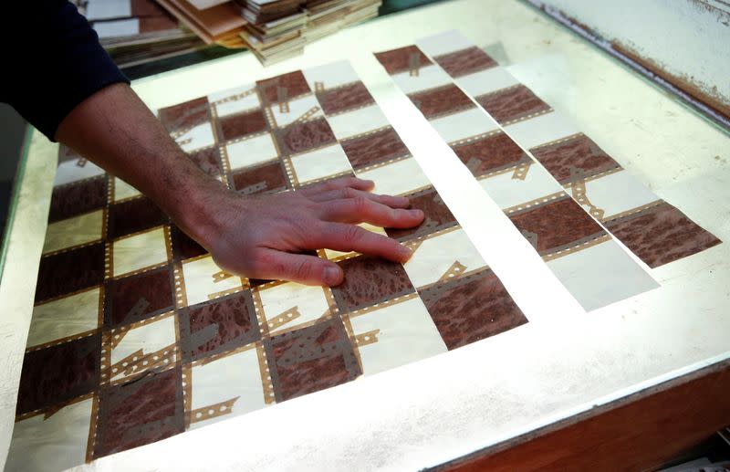A worker makes a chess board at the Rechapados Ferrer factory at their factory in La Garriga