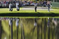 Tiger Woods and Will Zalatoris skip golf balls across the water on the 16th hole during a practice round in preparation for the Masters golf tournament at Augusta National Golf Club Monday, April 8, 2024, in Augusta, Ga. (AP Photo/George Walker IV)