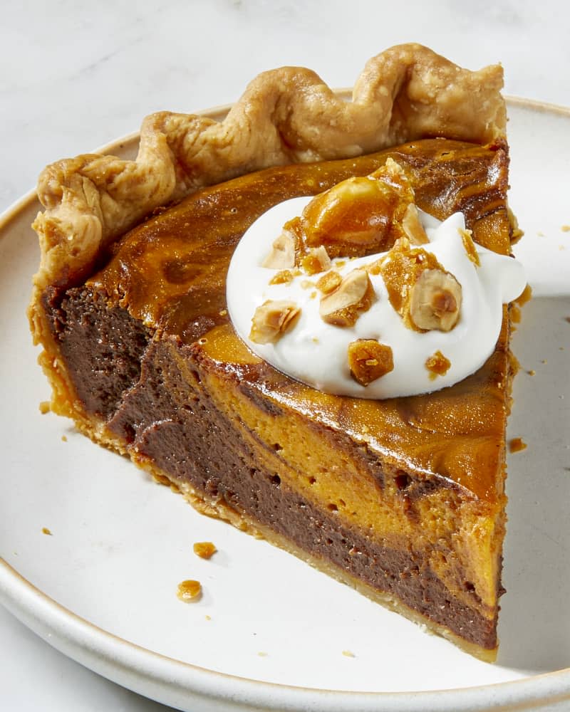 Angled view of a slice of pie on a white plate with a dollop of whipped cream.