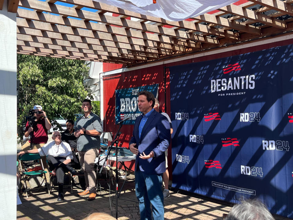Ron DeSantis speaks at an event put on by his presidential campaign, with official campaign logos behind him. (Alec Hernández / NBC News)