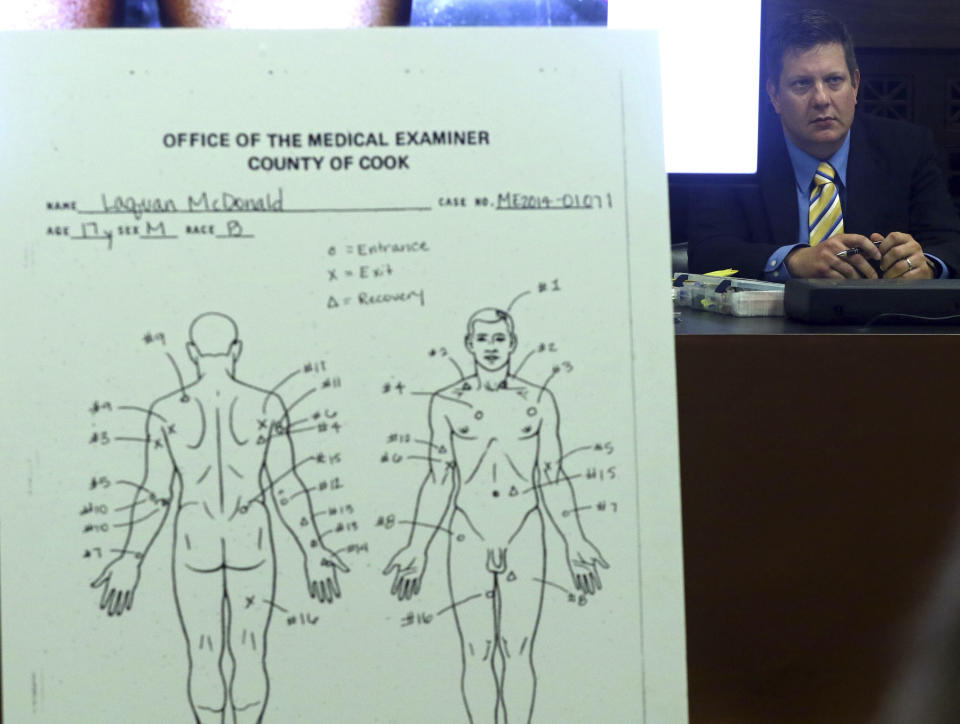 Chicago police Officer Jason Van Dyke, right, views an enlarged diagram of bullet entry and exit wounds found on the body of Laquan McDonald, as the diagram is shown to the jury during the trial for the shooting death of McDonald by Van Dyke, at the Leighton Criminal Court Building Wednesday, Sept. 19, 2018, in Chicago. (John J. Kim/ Chicago Tribune via AP, Pool)