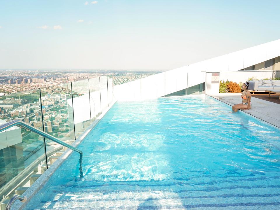 The author sits on the edge of the pool facing the NYC skyline.