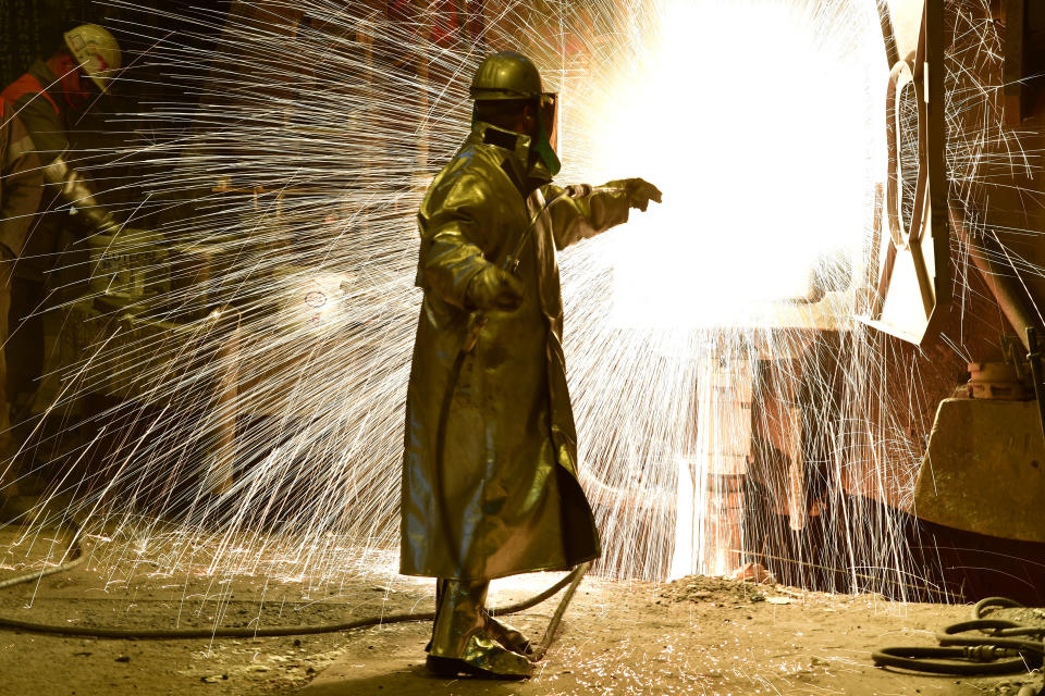 An employee works in front of the blast furnace past rolls of sheet steel at a mill of German steel producer Salzgitter AG on March 1, 2018 in Salzgitter, Germany. Photo: Alexander Koerner/Getty Images