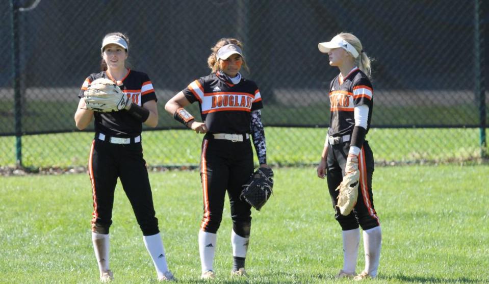 Frederick Douglass softball outfielders, from left, Rachael Harris, Kasia Parks and Krissa Van Schoyck chatted as they waited for the pitcher to warm up between innings of the Broncos’ 14-5 win at Paul Laurence Dunbar on Saturday.