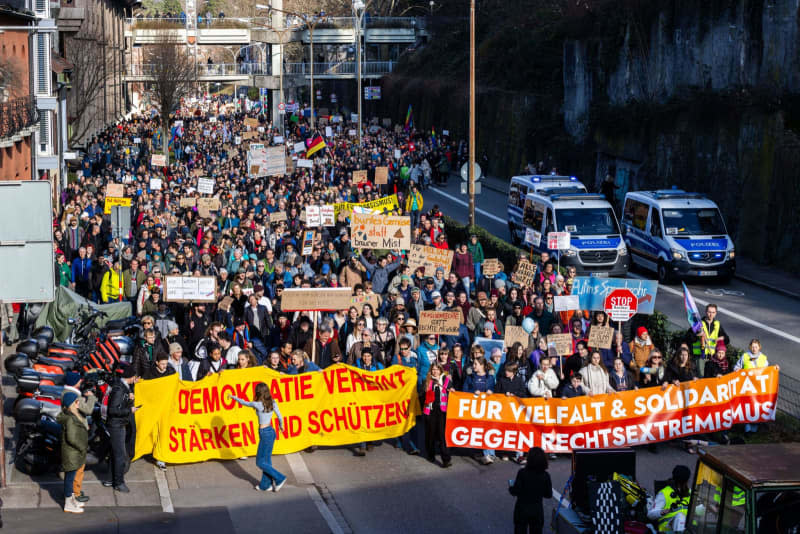 People walk through Freiburg during a demonstration against right-wing extremist activities while carrying banners with inscriptions such as "For diversity & solidarity against right-wing extremism", "# Strengthen and protect democracy united!" or "Human rights instead of right-wing people". Philipp von Ditfurth/dpa