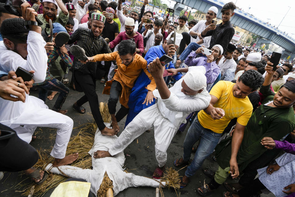 Indian Muslims trample an effigy of Nupur Sharma, the spokesperson of governing Hindu nationalist party as they react to the derogatory references to Islam and the Prophet Muhammad in Kolkata, India, Friday, June 10, 2022. Thousands of Muslims emerging from mosques after Friday prayers held street protests and hurled rocks at the police in some Indian towns and cities over remarks by two officials from India’s ruling party that were derogatory to the Prophet Muhammad. (AP Photo/Bikas Das)