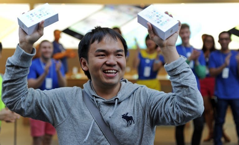 Jimmy Gunawan, 33, proudly shows his new iPhones outside Apple's flagship store in Sydney's central business district on September 20, 2013 after being first through the door