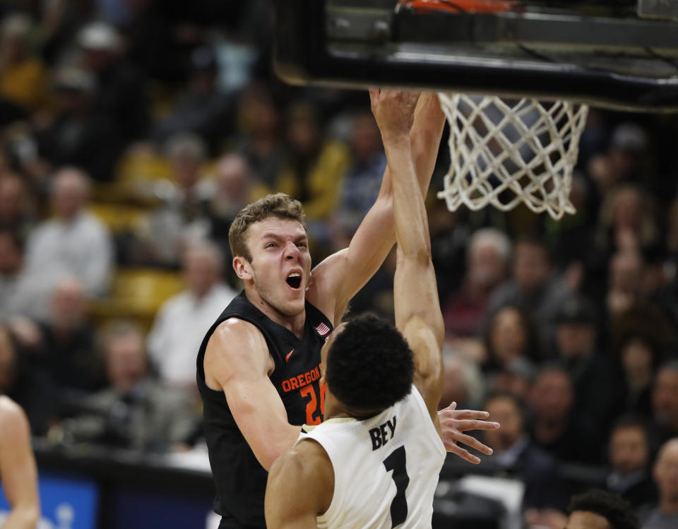 Oregon State forward Kylor Kelley, left, tosses the ball over Colorado guard Tyler Bey for a basket in the first half of an NCAA college basketball game Sunday, Jan. 5, 2020, in Boulder, Colo. (AP Photo/David Zalubowski)