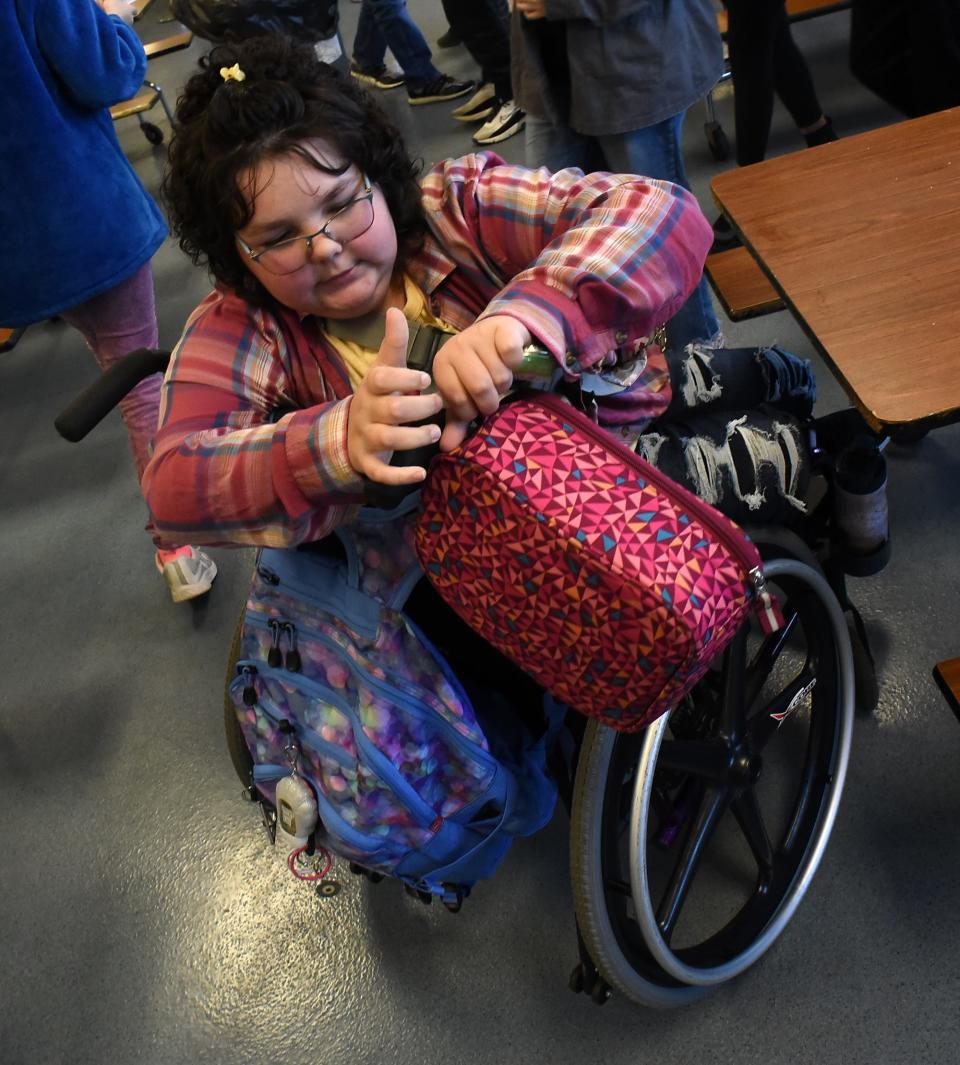 Elly packs up after lunch to go to class.