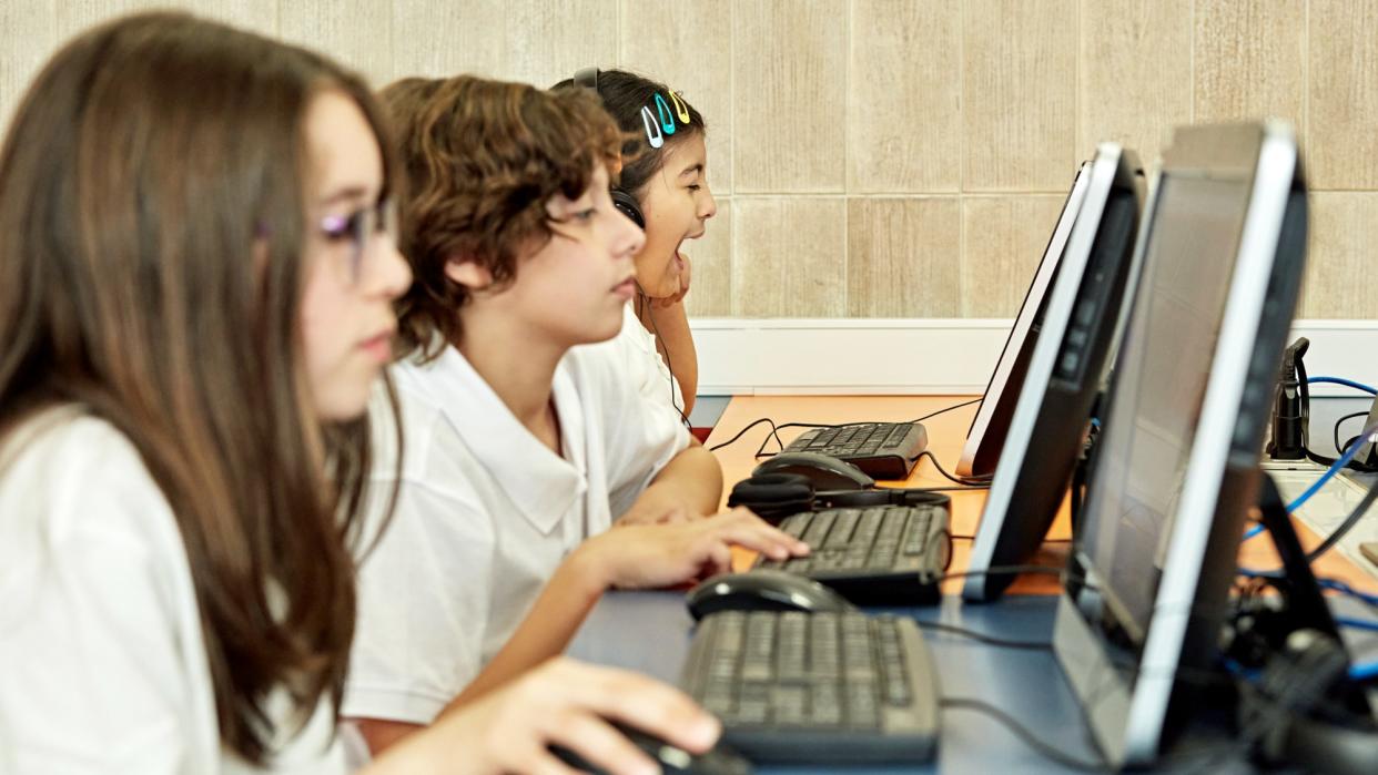  Children using a row of computers. 