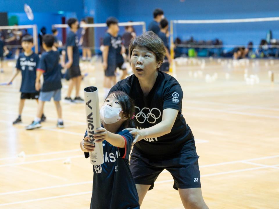 陳嬥筌教練手把手教導小選手接球技巧。(達克運動提供)