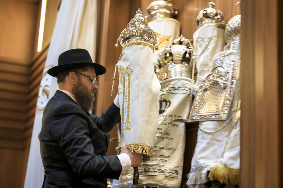 Rabbi Yehuda Teichtal prepares Torah scrolls at the synagogue of the Chabad community prior to the first Shabbat service after the Hamas attacks on Israel, in Berlin, Germany, Friday, Oct. 13, 2023. (AP Photo/Markus Schreiber)