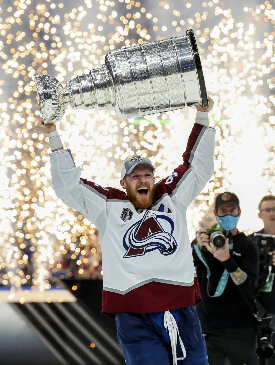 Colorado Avalanche left wing Gabriel Landeskog (92) holds the Stanley Cup after the Avalanche defeated the Tampa Bay Lightning 2-1 in Game 6 of the NHL hockey Stanley Cup Finals on Sunday, June 26, 2022, in Tampa, Fla. (Dirk Shadd/Tampa Bay Times via AP)