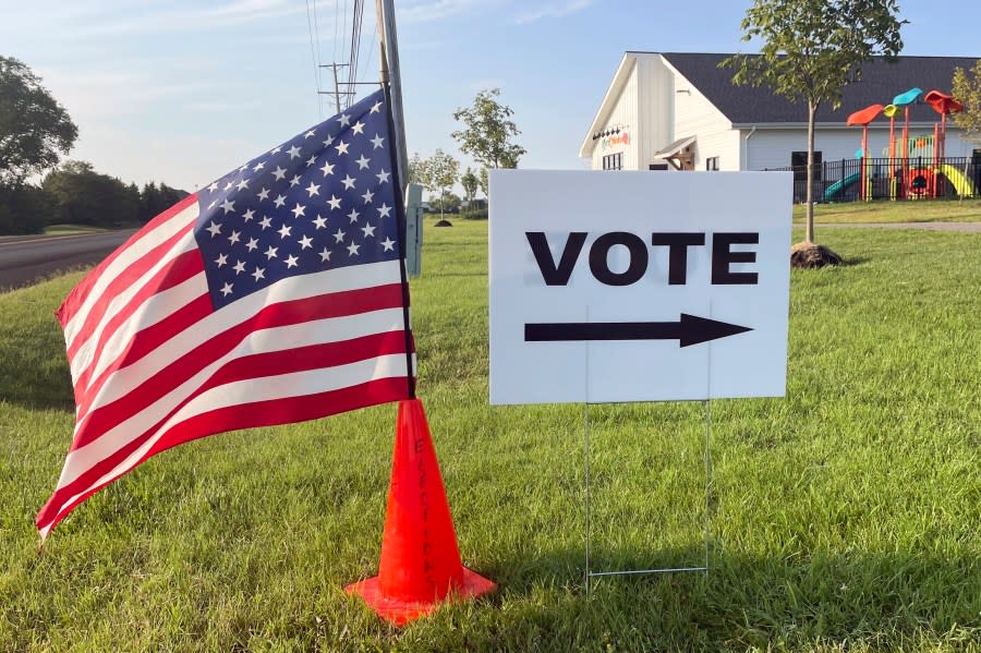 An American flag waves in the breeze next to a sign directing Ohioans to vote inside Tharp Sixth Grade School, Tuesday, Aug. 8, 2023 in Hilliard, Ohio. It’s the final day that Ohio citizens can vote in a GOP-rushed special election on whether to make the state constitution harder to amend, likely having direct impact on abortion rights in the state. (AP Photo/Samantha Hendrickson)